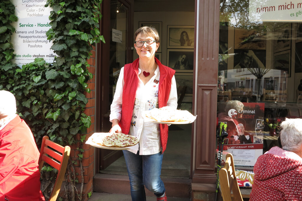 eine frau hält zwei flammkuchen in ihren Händen