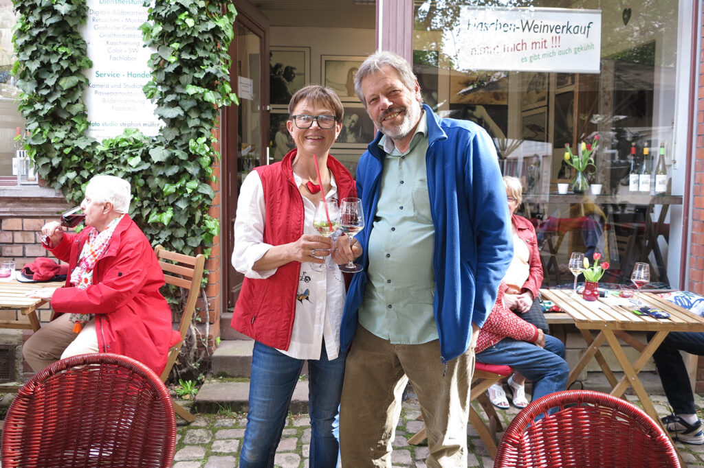 frau und mann halten jeweils ein Weinglas in der Hand.